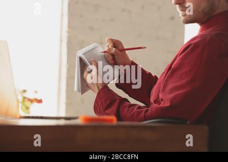 Caucasian entrepreneur, businessman, manager working in office, close up. Making notes, writing report or doing task. Concept of work, finance, business, success and leadership. Deadline, hurry up. Stock Photo