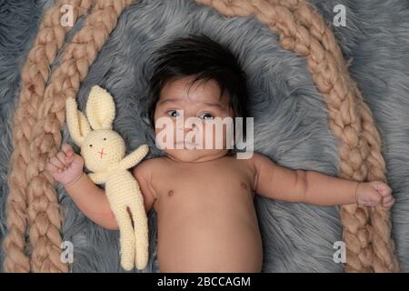 Little baby with teddy bear lying on the fur bed stock photo Stock Photo