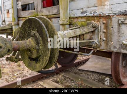 Old train carriage on rails, white wooden train carriage. Old style hook railway coupling and buffers for linking freight train wagons. Stock Photo