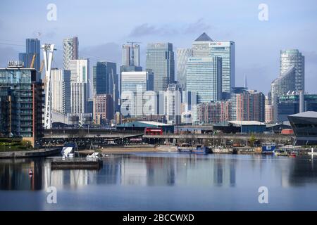 The Canary Wharf skyline is reflected in the Royal Victoria Dock in London. Stock Photo