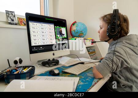 Boy, primary school children, home learning, doing homework, distance learning, virtual classroom, chat with teachers and classmates, home schooling, Stock Photo