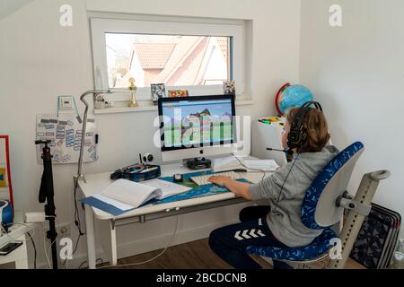 Boy, primary school children, home learning, doing homework, distance learning, virtual classroom, chat with teachers and classmates, home schooling, Stock Photo