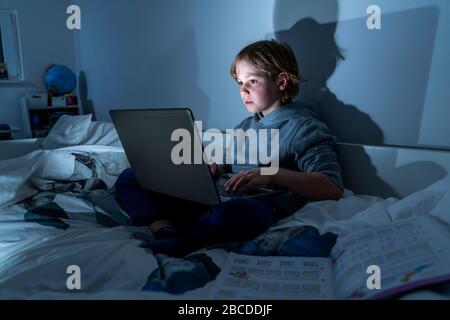 Boy, at home on the computer, laptop, in the kids' room, playing a game, Stock Photo