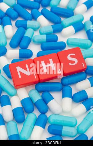 NHS letters tiles & assorted blue pills. For NHS 75th birthday, NHS heroes, NHS prescriptions, UK National Health Service, medicine in UK Stock Photo
