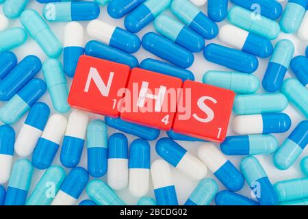 NHS letters tiles & assorted blue pills. Metaphor NHS in Covid 19 pandemic, NHS heroes, NHS prescriptions, UK National Health Service, medicine in UK