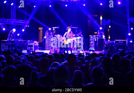 Defocused concert scene. blurred lights, stage and silhouette crowd people. Stock Photo