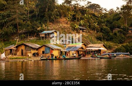 A part of a village community living beside the Sangu River in houses made of Bamboo. The people use the boats to commute their daily needs. Stock Photo