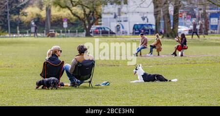 Hamburg, Germany. 04th Apr, 2020. People sit in a park on the outer Alster in the meadow. To contain the spread of the coronavirus, it is forbidden to sit outside on benches and meadows. Credit: Markus Scholz/dpa/Alamy Live News Stock Photo