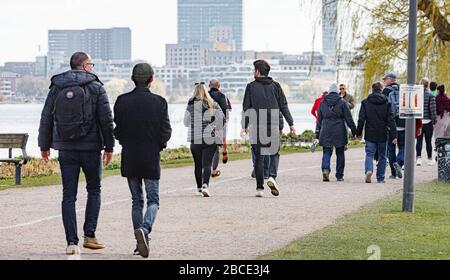 Hamburg, Germany. 04th Apr, 2020. People go for walks along the Outer Alster. To stem the spread of the coronavirus, it is forbidden to sit outside on benches and meadows. Credit: Markus Scholz/dpa/Alamy Live News Stock Photo