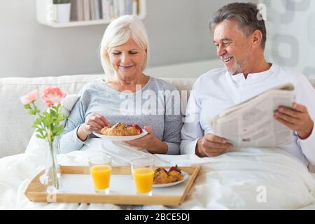 Senior couple enjoying breakfast in bed Stock Photo