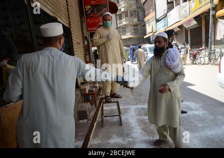 Peshawar, Pakistan. 04th Apr, 2020. People stand at distance to buy grocery items during a nation-wide lockdown to contain outbreak of the corona virus (Photo by Hussain Ali/Pacific Press) Credit: Pacific Press Agency/Alamy Live News Stock Photo