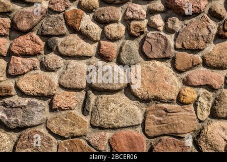 Stones fixed with cement mortar. A wall of pebble stones. Stock Photo