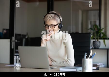 Happy business woman looking at laptop screen in office. Stock Photo