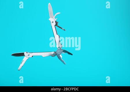 The multitool multi-function tool hovers on a blue background. The concept of an expanded multi-tool with free space. Clipping path included isolate Stock Photo