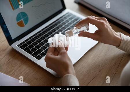 Above close up young woman applying antibacterial gel on tissue. Stock Photo