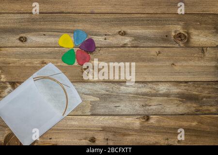 acoustic guitar accessories, strings, picks on wooden background Stock Photo