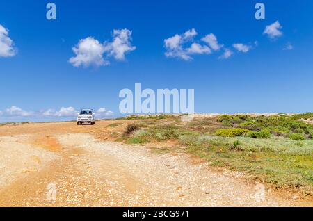 Paros, Greece - April 8, 2014: Suzuki Jimny car parked on desert coast of Paros island Stock Photo