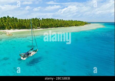 Sailing yacht anchoring in the shallow waters of suwarrow atoll, cook islands, polynesia, pacific ocean Stock Photo