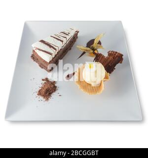 Three-chocolate cake plate with a scoop of vanilla ice cream and a physalis. Stock Photo