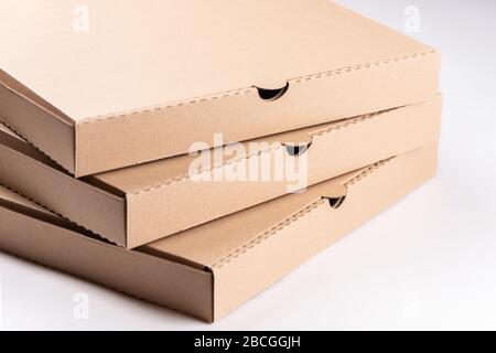 Stack of cardboard pizza boxes on white background  close up Stock Photo