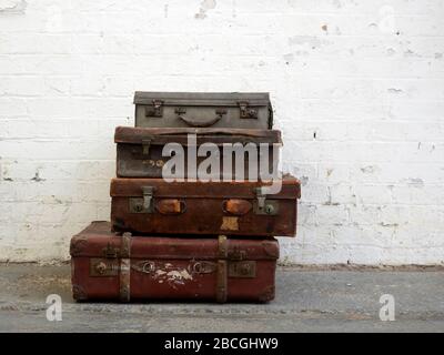 Close-up of old suitcases against white wall. Concept of travel. Stock Photo