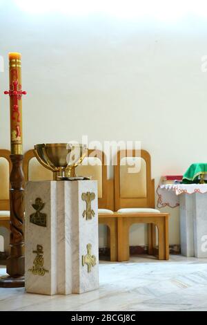 The decoration of the Roman Catholic church. Filled with holy water and gilded cup-shaped baptismal font one hundred on the presbytery in the church. Stock Photo