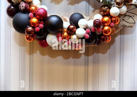 A festive wreath of Christmas baubles as a Christmas decoration. A decorative Christmas wreath that glitters on the wall. Stock Photo