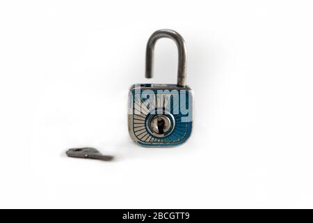 An open old padlock with a key, white background. Stock Photo