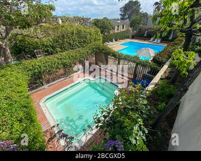 Community swimming pool and jacuzzi inside typical private condo complex. in Solana Beach, San Diego, California, USA. March 20th, 2019 Stock Photo