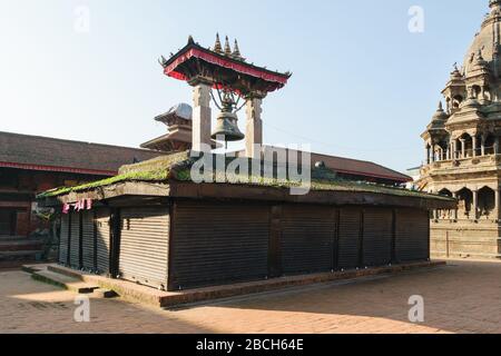 Bell porticoe and closed shops in Patan Durbar Square heritage site, Kathmandu, Nepal Stock Photo