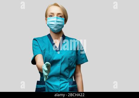 medical doctor nurse woman wearing protective mask and latex gloves - ready for handshake gesture Stock Photo