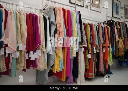 Close up colorful and shinny Indian bridal wedding dress in a shop. Female party clothes. Indian party wear hanging in a boutique store. :Udaipur Indi Stock Photo