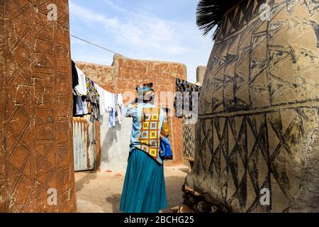 Africa, Burkina Faso, Pô region, Tiebele. Cityscape view of the royal court village in Tiebele.  A woman walks to hang some laundry Stock Photo