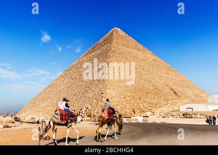 Cairo, Egypt - December 31, 2014: View at the Pyramid in Giza and tourists riding on the camelcamels Stock Photo