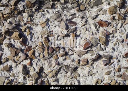 concrete wall mixed with small natural stones, background texture Stock Photo