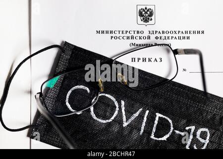 View of the order form of the Ministry of Health of the Russian Federation and black medical mask with inscription 'COVID-19' Stock Photo