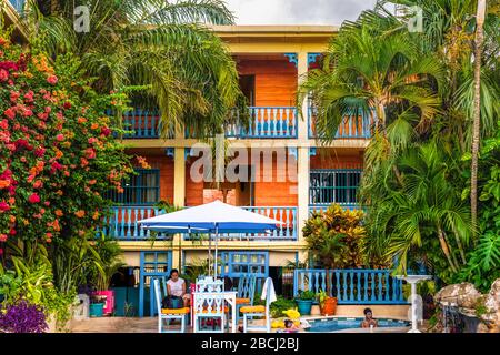 Flores, Guatemala - December 14, 2016: Tourists at the hotel La Casona de la Isla rest area with swimming pool. It is located in historic district of Stock Photo