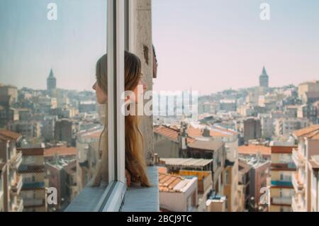 Beautiful girl with blond hair looking from the window, old district of Istanbul, Turkey Stock Photo