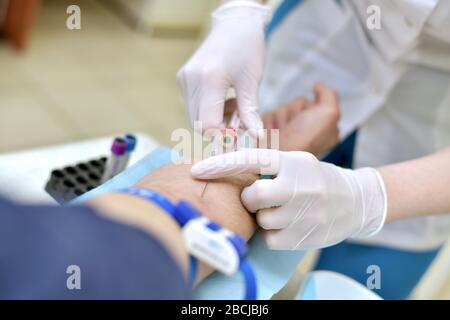 Venous blood collection from the patient in the lab. The stage of the vacuum tube connection. Stock Photo