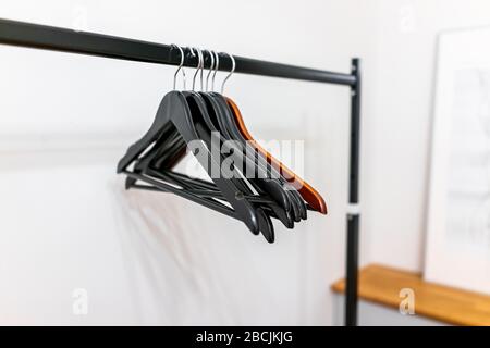 Closeup of closet hangers in empty room on pole stand in modern minimalist hotel or house room with bright light Stock Photo