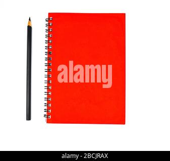Black pen beside a red color covered single note paper diary isolated on an empty white background Stock Photo