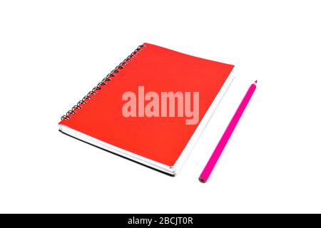 Pink pencil beside a red color covered single note paper diary isolated on an empty white background Stock Photo