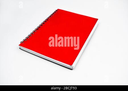 Side view of a red color covered single note paper diary isolated on an empty white background Stock Photo