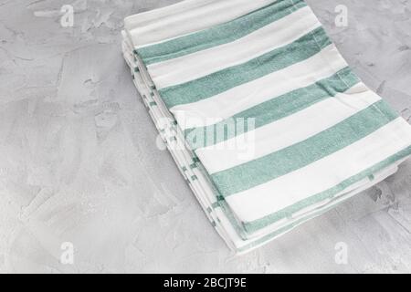 Striped green and white kitchen towels on gray background, top view, copy space Stock Photo