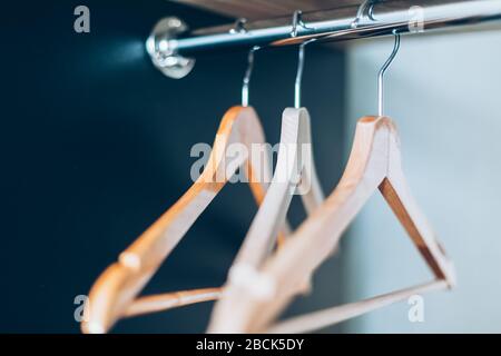 Empty Wooden hangers on rail in closet. Lifestyle composition with natural light and copy space Stock Photo