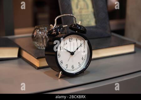 Alarm clock on the table in the bedroom. Interiors Stock Photo