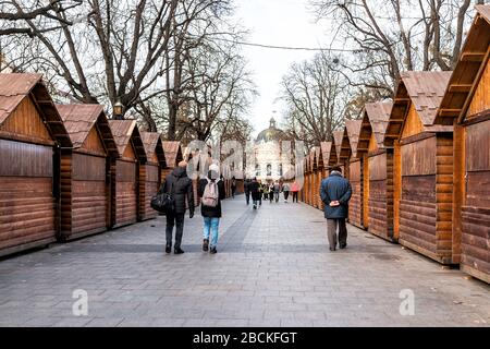 Lviv, Ukraine - January 21, 2020: Historic Ukrainian Lvov city in old town with people walking through Christmas market on center downtown park alley Stock Photo