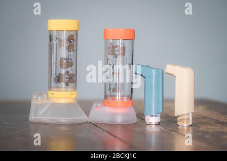 London, UK - April 3, 2020 - Ventolin and Clenil inhalers and Aerochamber spacers (child and infant); common medications for asthma treatment Stock Photo