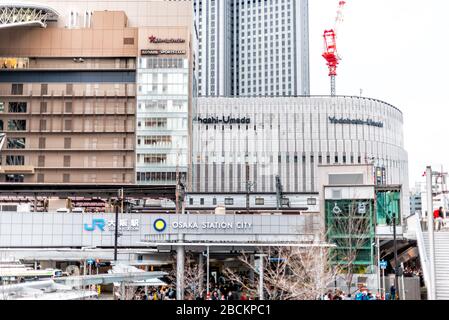 Osaka, Japan - April 13, 2019: Cityscape of modern buildings with construction cranes near station and JR sign in downtown Japanese city Stock Photo