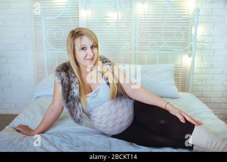 Pregnant girl with a big belly in a studio room Stock Photo